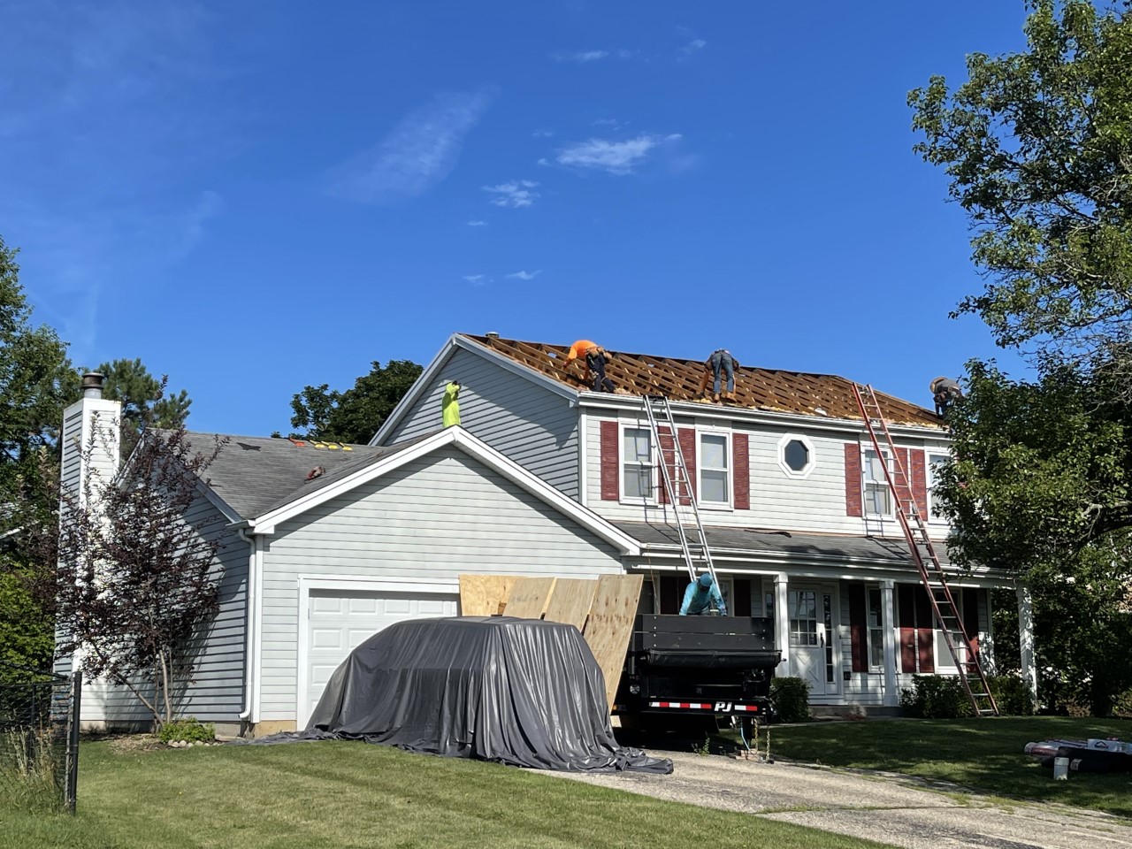 roofers installing a new roof base and shingles
